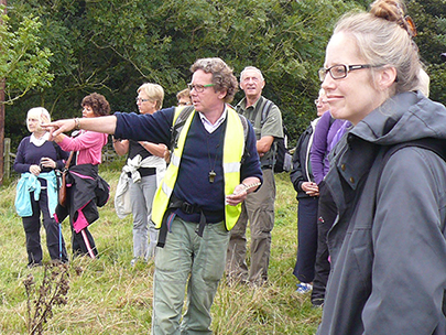 Phil Howe leads a group of walkers and pauses to discuss a point of detail with them